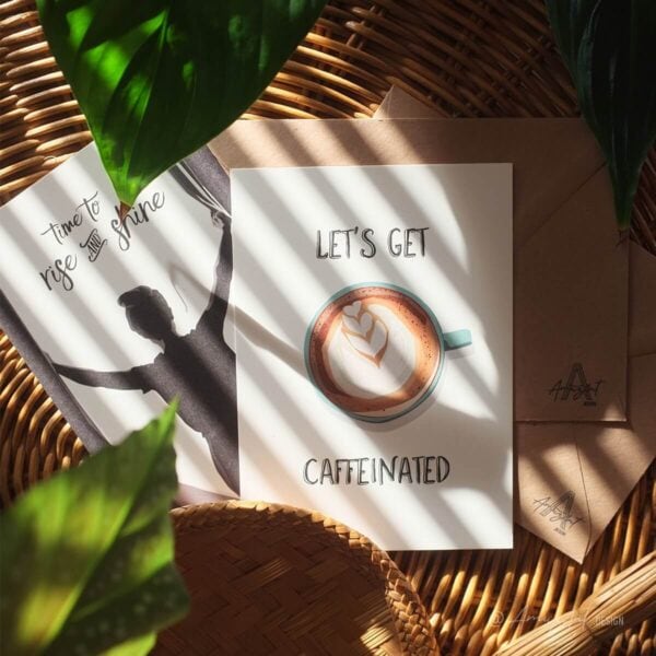 Mood image of 2 AmuzAnt greeting cards, 1 with the text "Let's Get Caffeinated and a coffee illustration, and 1 with the text "Time to Rise & Shine" and an illustration of a girl.